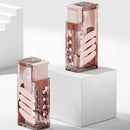 Two transparent perfume bottles with intricate designs on a white platform